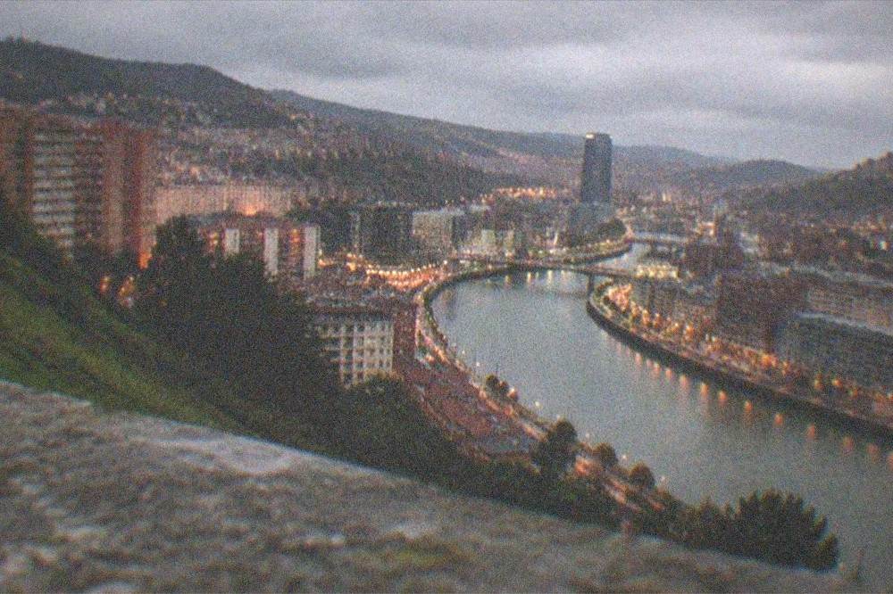 Evening view over Bilbao city lights from a hillside above the estuary