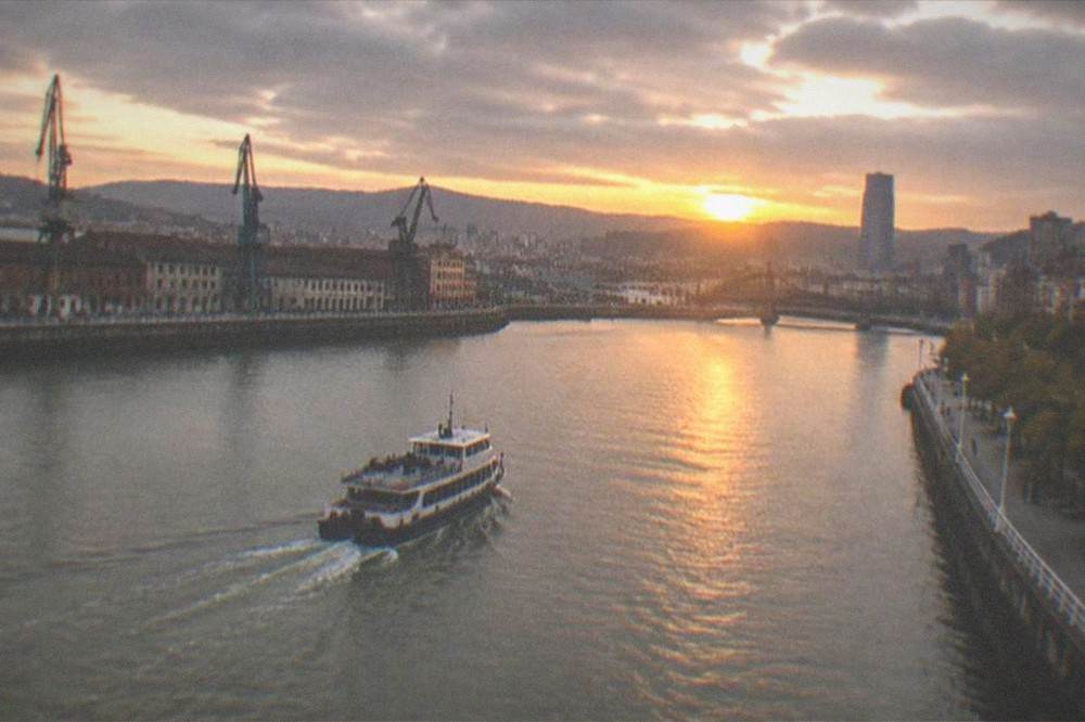 Sunset over the Nervion river in Bilbao with the city skyline in silhouette