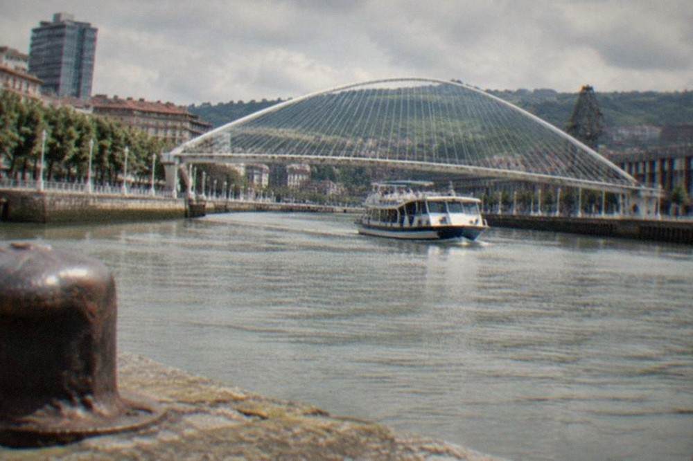 The Zubizuri footbridge with its white curved arch standing over the Nervion river