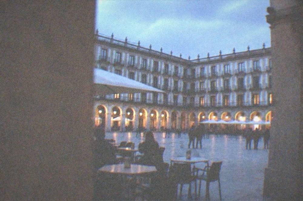 The arcaded Plaza Nueva in Bilbao's Old Town with cafe tables under the stone arches