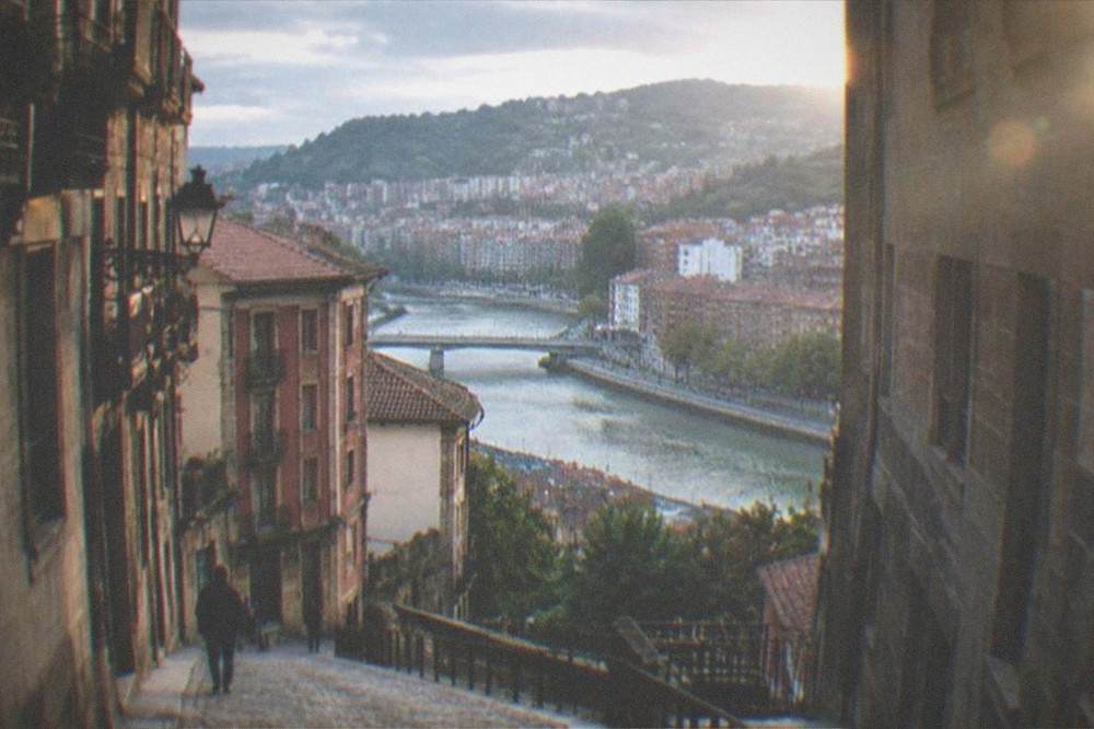 A steep cobbled lane in Bilbao's Old Town climbing between tall stone buildings