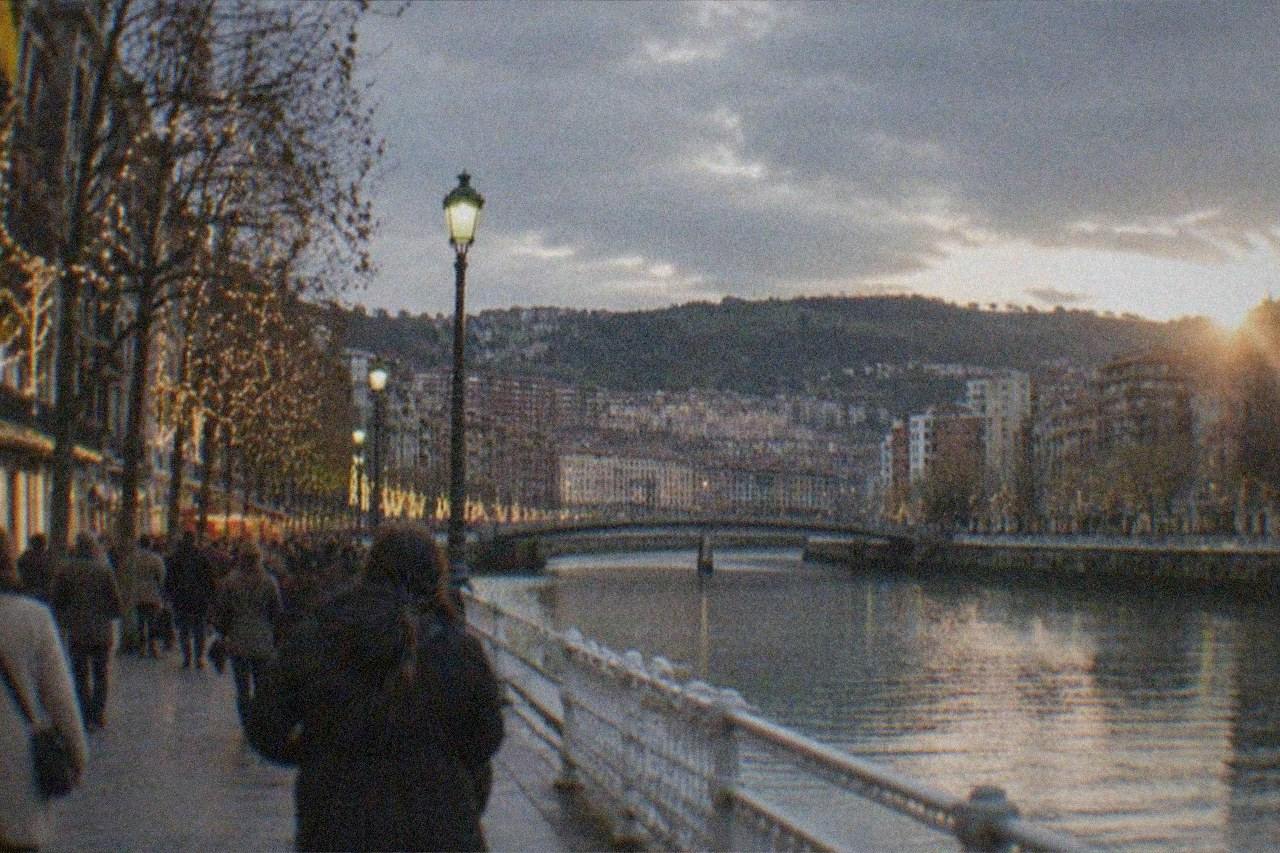 Festive lights and shoppers on a decorated street in Bilbao city centre at dusk