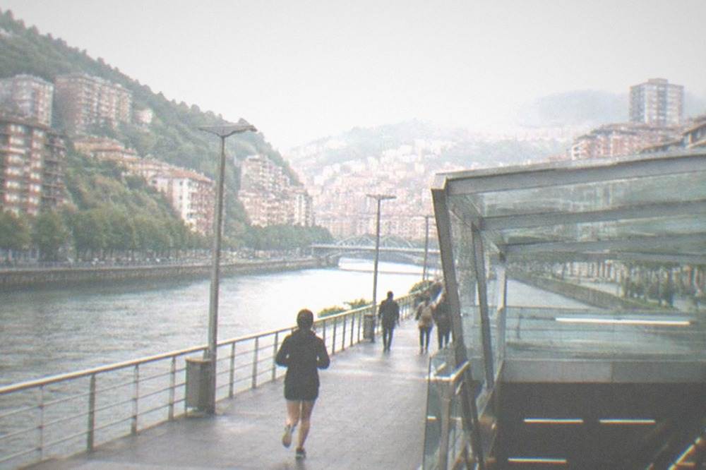 Modern Bilbao metro station entrance with a glass canopy above street level