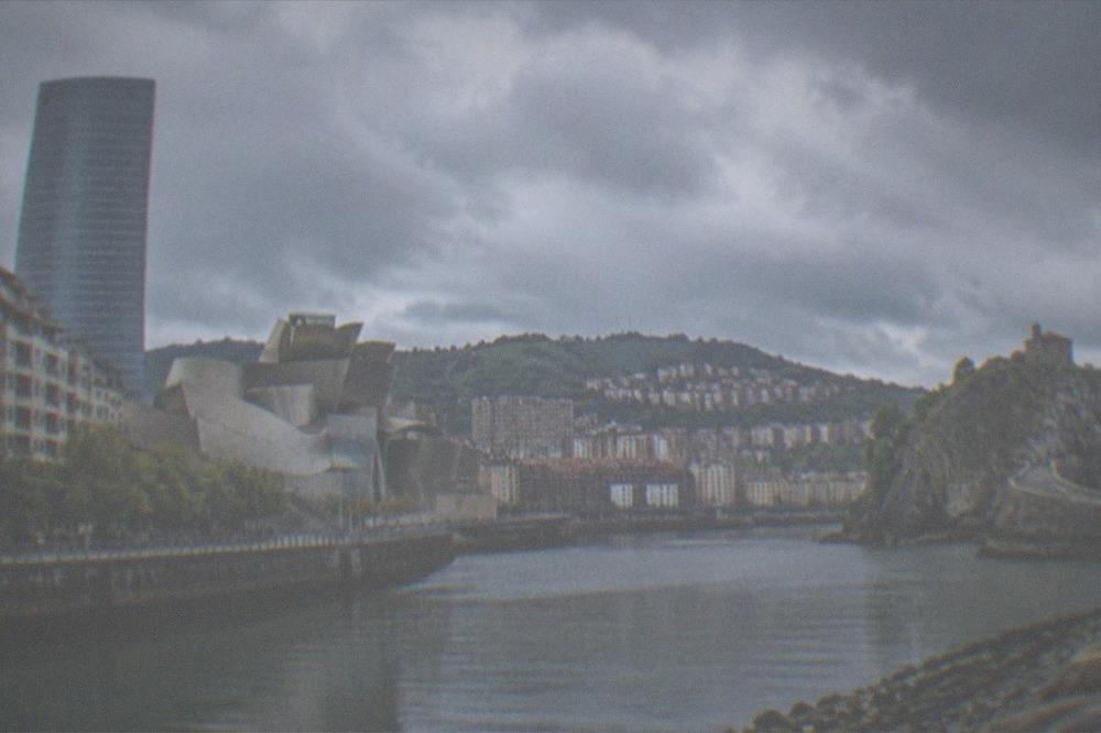 Dramatic rocky Basque coastline with a stone causeway leading to a small island hermitage