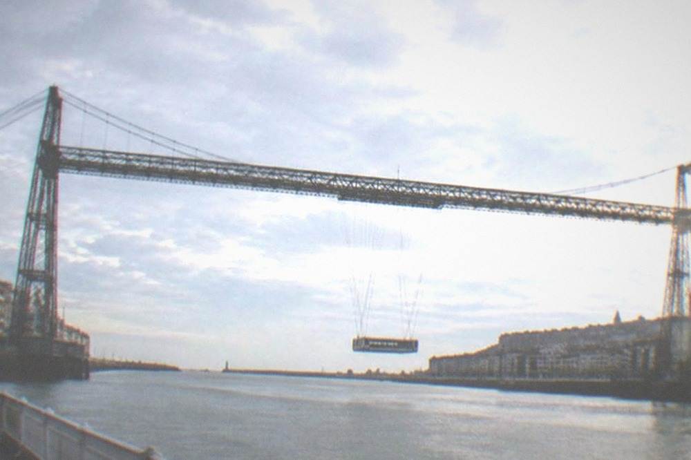 The iron lattice structure of the Vizcaya transporter bridge seen from the Portugalete riverbank