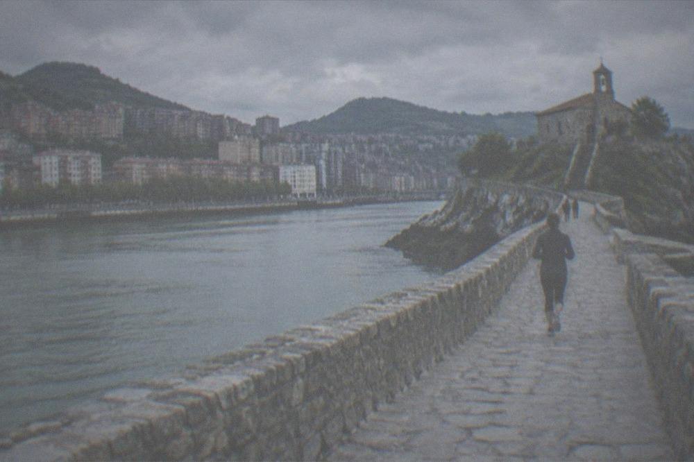 A coastal stone causeway leading to a hermitage chapel on a rocky islet in the Basque Country
