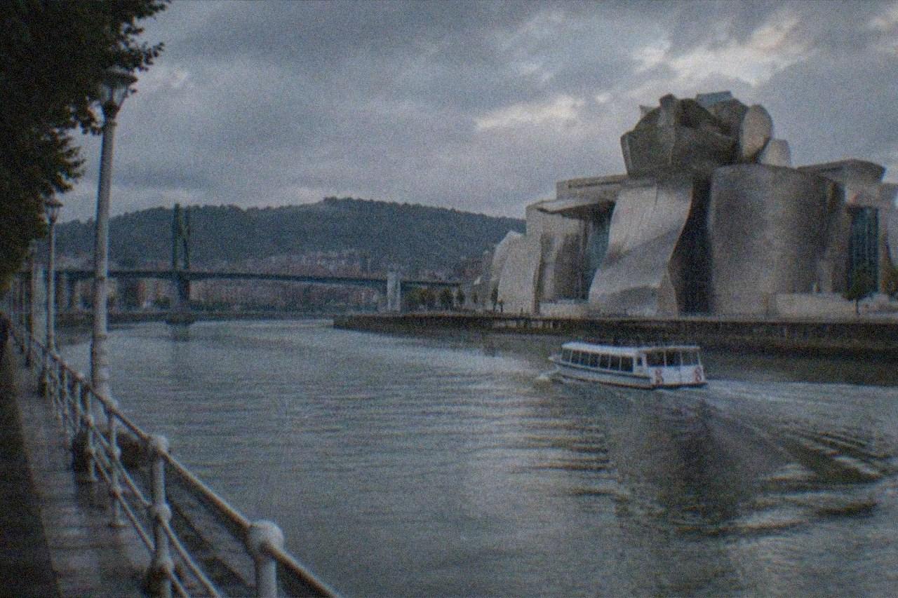 The Guggenheim Museum Bilbao beside the Nervion estuary on a quiet, overcast morning