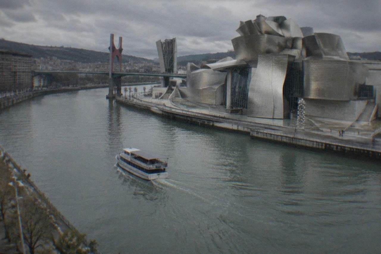 The Guggenheim Museum Bilbao's titanium curves reflecting morning light beside the Nervion estuary