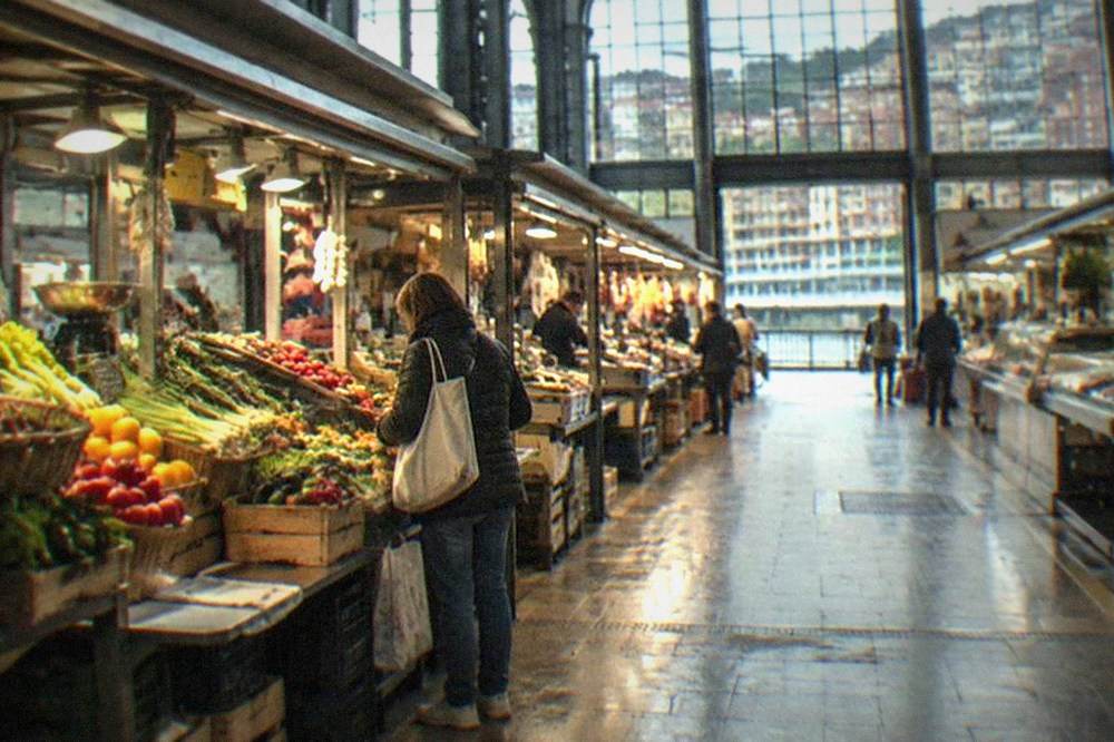 The Ribera Market hall in Bilbao with a visitor browsing the stalls alone