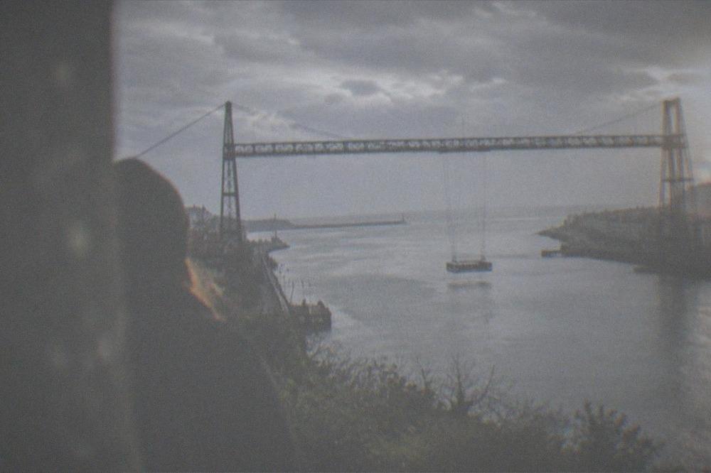 A traveler looking out at the Atlantic coast from the cliffs above the Vizcaya Bridge between Getxo and Portugalete