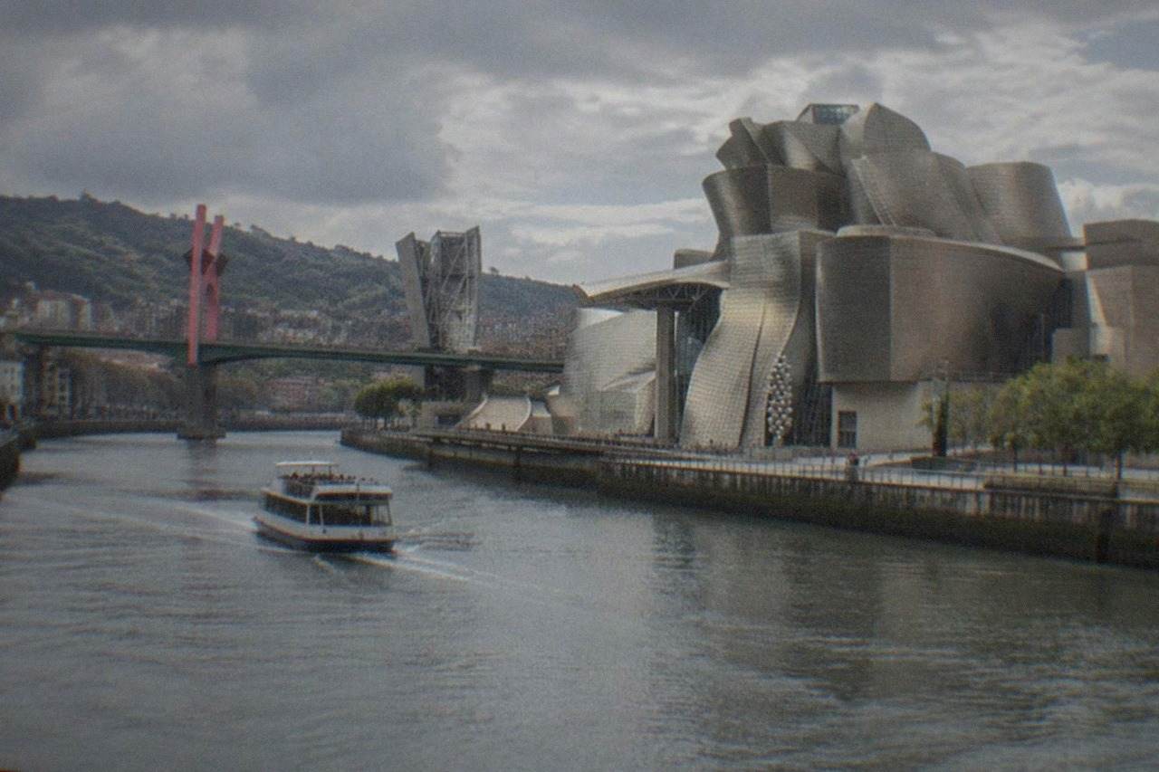 The Guggenheim Museum Bilbao beside the Nervion river on a bright summer day