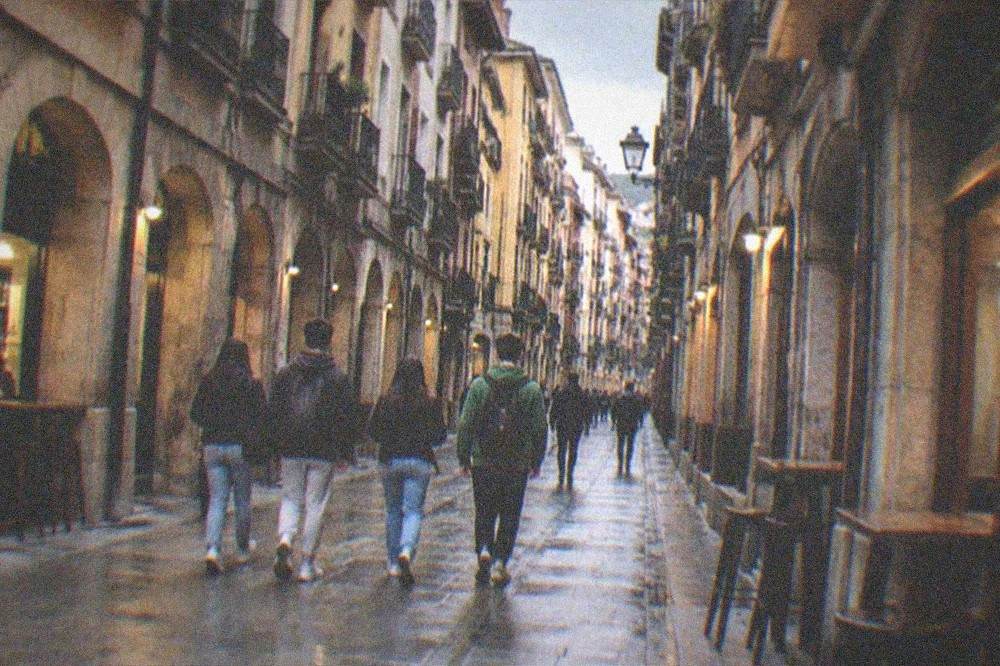 Teenagers walking together through the Seven Streets of Bilbao's old town in the evening