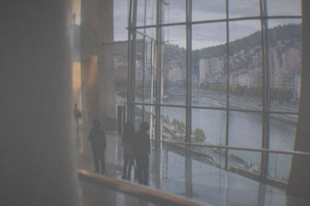Children looking up at the tall atrium inside a bright modern museum building in Bilbao