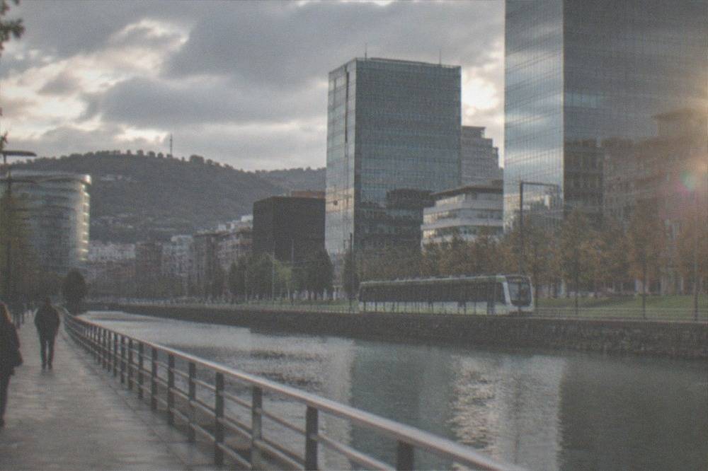 The Bilbao tram passing modern buildings along the Abandoibarra riverfront