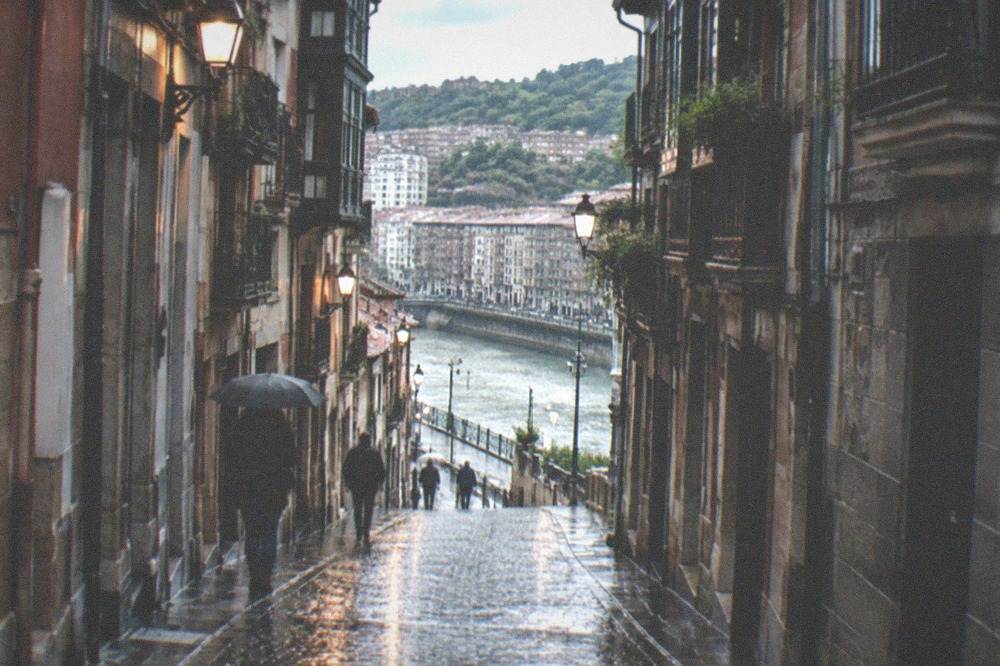 Wet cobblestones shining under lights in one of the seven narrow streets of Bilbao's old town