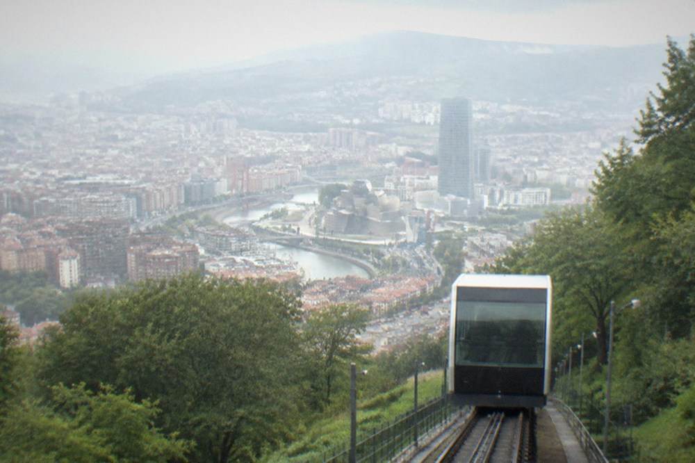 The Artxanda funicular car ascending the hill with Bilbao city below