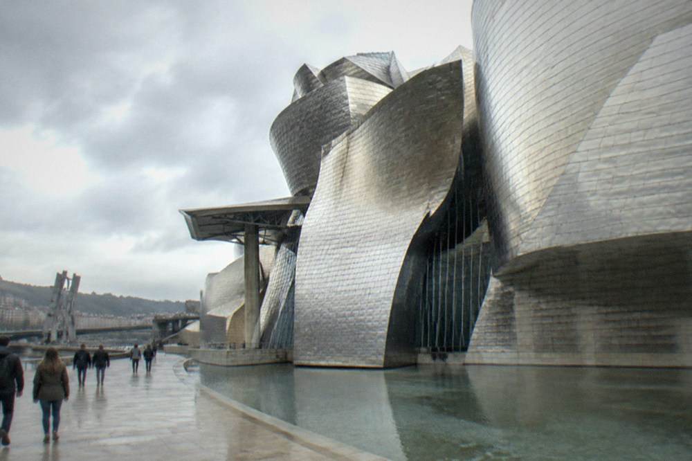 Visitors walking past the titanium curves of the Guggenheim Museum in Bilbao