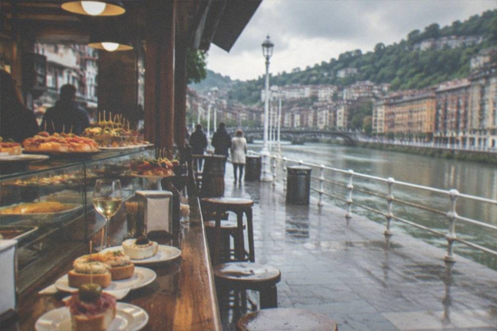 A busy pintxos bar counter in Bilbao's Old Town with tapas on display