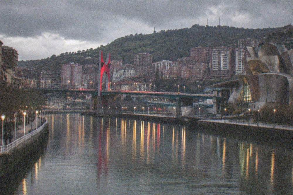 The Bilbao estuary at dusk with the La Salve bridge lights reflecting on the water