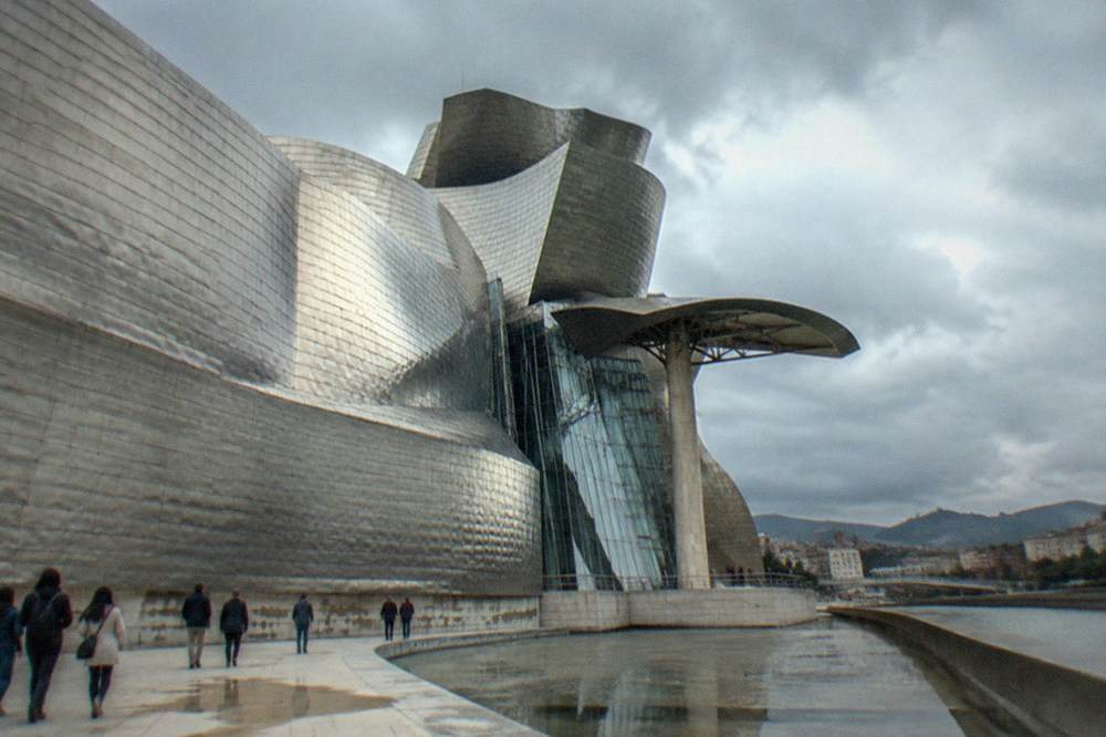 Visitors walking beside the titanium curves of the Guggenheim Museum in Bilbao on a Saturday morning