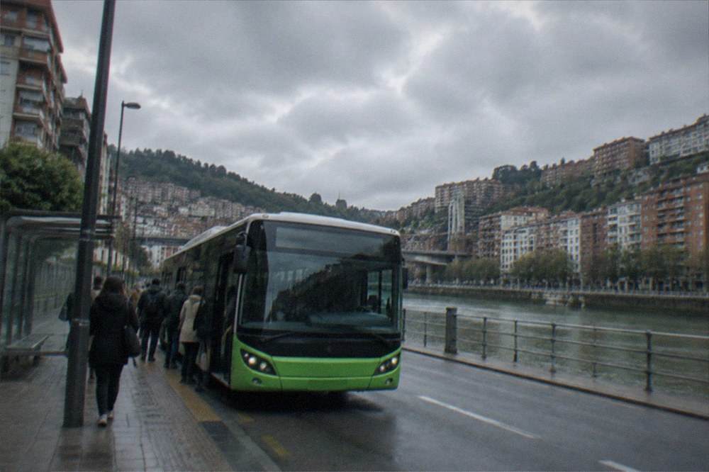 A low-floor city bus at a stop on a Bilbao street with the airport route number displayed